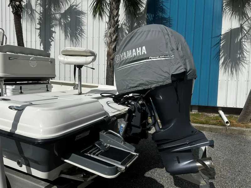 Slide: The Image of 2018 Triton 220LTS boat with Yamaha outboard motor, docked near palm trees. - 3