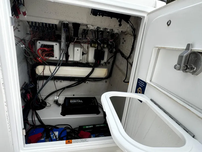 Slide: The Image of 2018 Triton 220LTS boat electrical compartment with wiring and battery setup. - 7