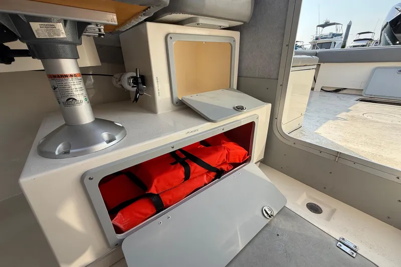 Slide: The Image of 2024 Defiance Admiral 220 EX boat interior with storage compartments and life jackets. - 6
