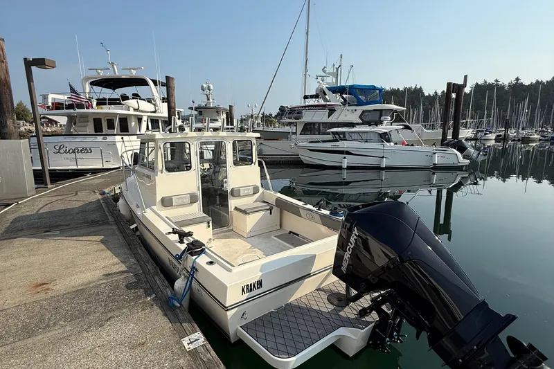 Slide: The Image of 2024 Defiance Admiral 220 EX boat docked in a marina with other vessels. - 8