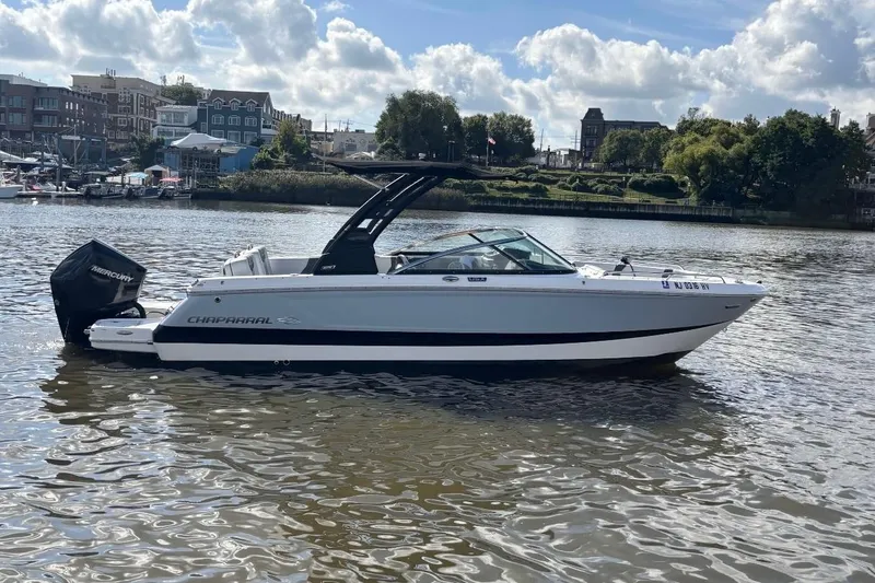 The Image of 2025 Chaparral 250 OSX boat on a scenic river with city backdrop. - 0