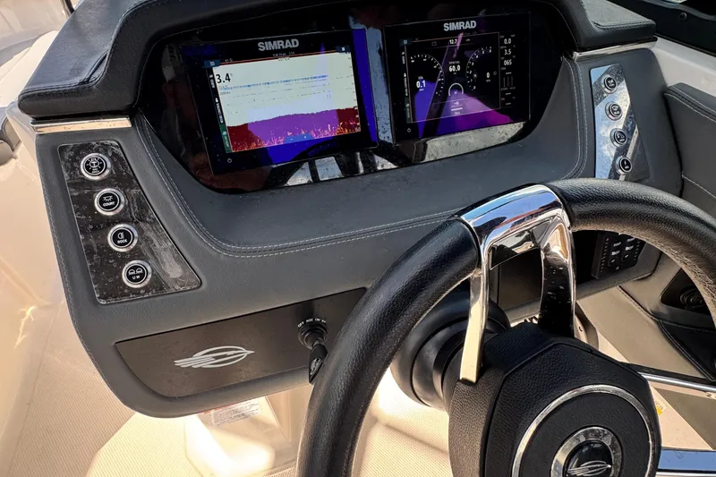 Slide: The Image of 2025 Chaparral 250 OSX dashboard with Simrad displays and steering wheel. - 11