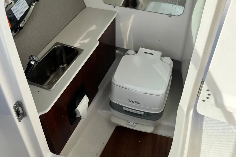 Slide: The Image of Compact bathroom in 2025 Chaparral 250 OSX boat with sink and portable toilet. - 13