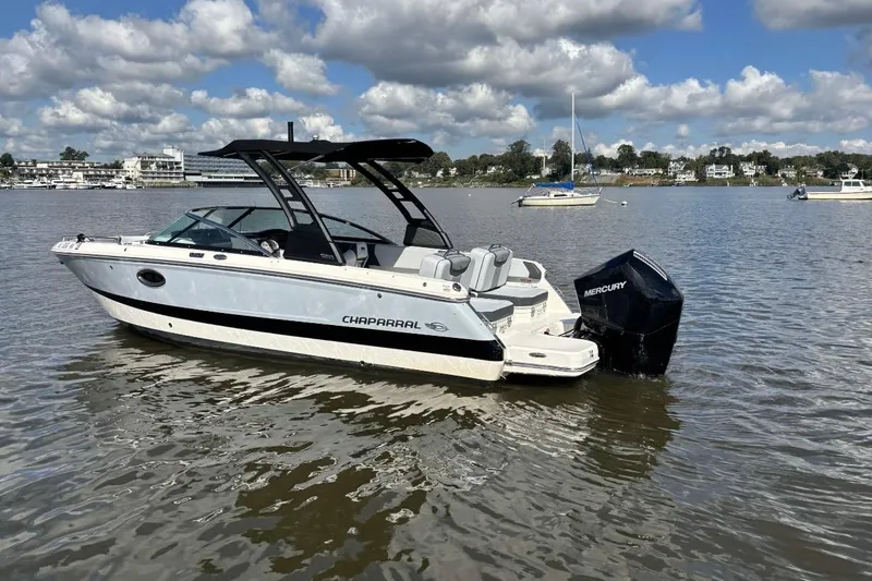 Slide: The Image of 2025 Chaparral 250 OSX boat on calm water under a partly cloudy sky. - 4