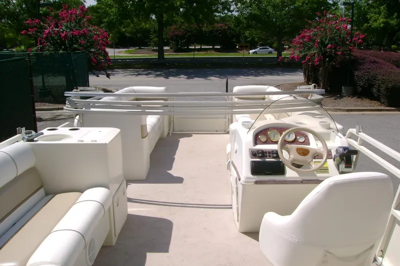 Slide: The Image of 2006 Bentley Pontoons 243 Cruise interior with white seating and steering console. - 2