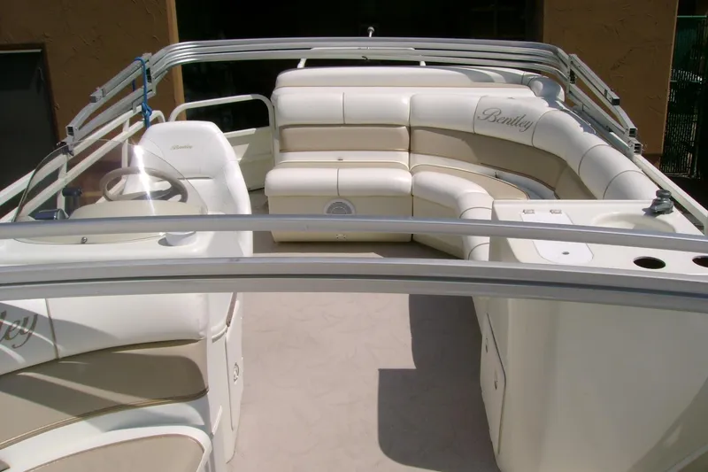 Slide: The Image of 2006 Bentley Pontoons 243 Cruise interior with white seating and steering console. - 5