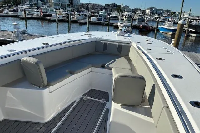 Slide: The Image of 2024 Cape Horn 34 XS boat interior with cushioned seating at a marina. - 10