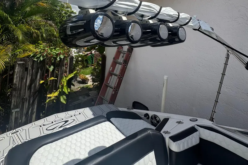 Slide: The Image of 2008 Regal 2520 FasDeck boat interior with speakers and seating, surrounded by greenery. - 37