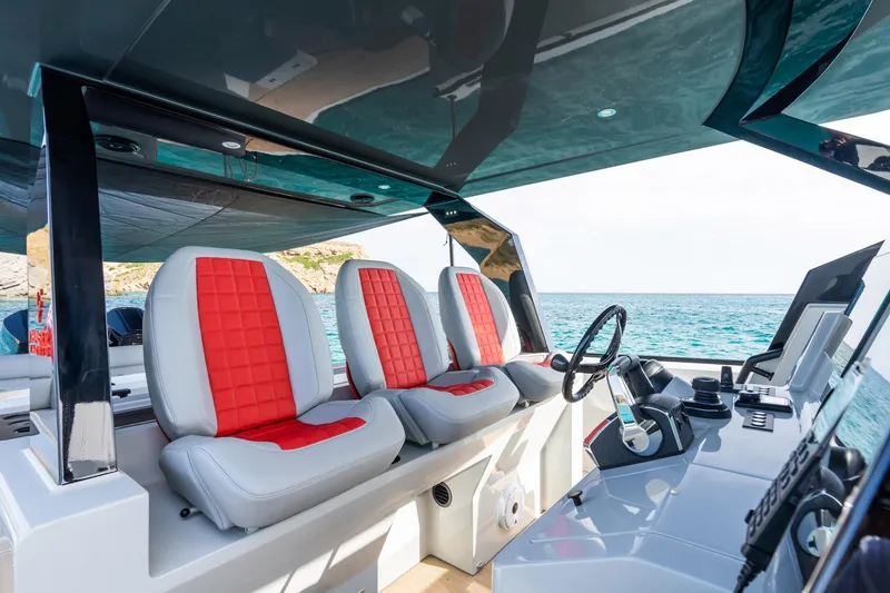 Slide: The Image of Interior of 2023 Chaser 54 Laguna boat with red and white seating, ocean view. - 15