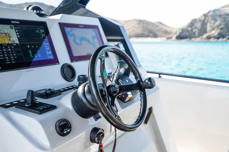 Slide: The Image of Steering wheel and navigation screens on 2023 Chaser 54 Laguna boat, with ocean view. - 17