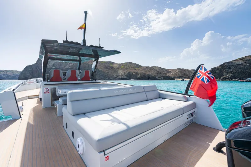 Slide: The Image of 2023 Chaser 54 Laguna yacht on turquoise water, featuring luxurious seating and a flag. - 25