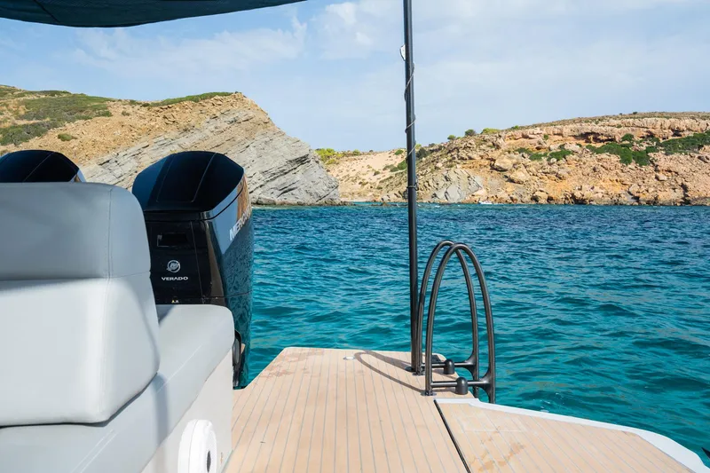 Slide: The Image of 2023 Chaser 54 Laguna boat on clear blue water near rocky coastline. - 28