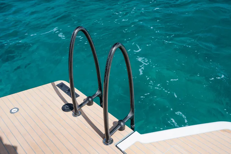 Slide: The Image of Boat swim platform with ladder on Chaser 54 Laguna, 2023 model, against clear blue water. - 29