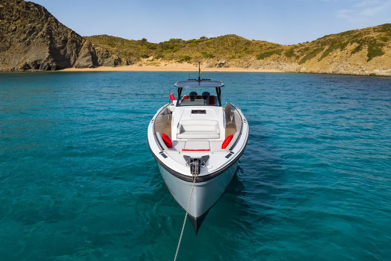 Slide: The Image of 2023 Chaser 54 Laguna boat anchored in clear turquoise water near a rocky coastline. - 33