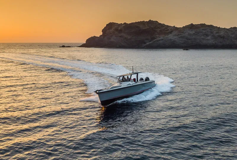 Slide: The Image of 2023 Chaser 54 Laguna boat cruising at sunset near rocky coastline. - 40