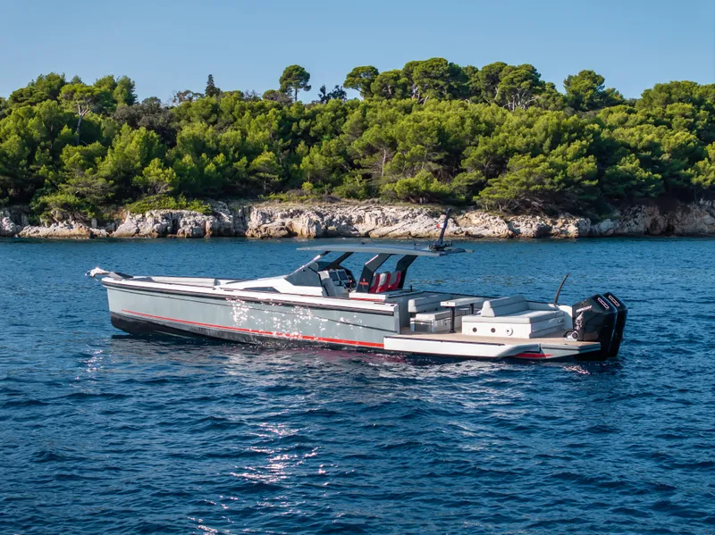 Slide: The Image of 2023 Chaser 54 Laguna yacht cruising near a lush, forested coastline. - 44