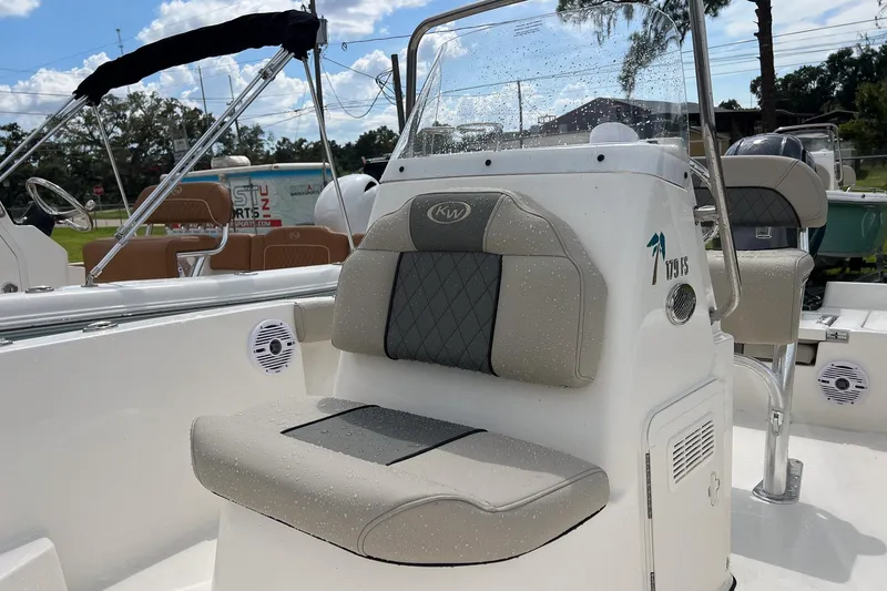Slide: The Image of 2026 Key West 179 FS boat interior with cushioned seating, wrapped in protective plastic. - 8