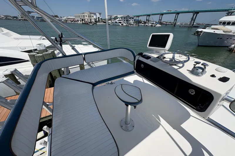 Slide: The Image of 2006 Rampage 38 Express boat helm with seating, docked near a bridge and waterfront buildings. - 19