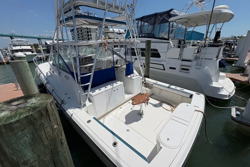 Slide: The Image of 2006 Rampage 38 Express boat docked at marina, featuring spacious deck and fishing equipment. - 5
