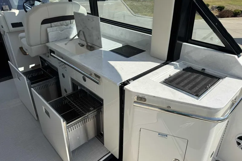 Slide: The Image of 2026 Regal 36 Grande Coupe yacht interior with modern kitchen and storage features. - 10