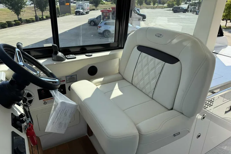 Slide: The Image of 2026 Regal 36 Grande Coupe helm with luxurious white leather seating and steering wheel. - 17