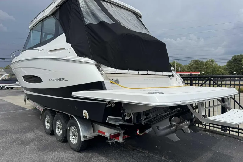 Slide: The Image of 2026 Regal 36 Grande Coupe boat on trailer, rear view, black and white design. - 2