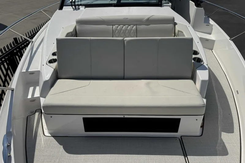 Slide: The Image of 2026 Regal 36 Grande Coupe boat seating area with modern design and cup holders. - 23