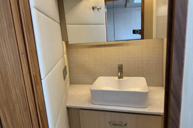 Slide: The Image of Modern bathroom interior of 2026 Regal 36 Grande Coupe yacht, featuring sleek sink and mirror. - 27