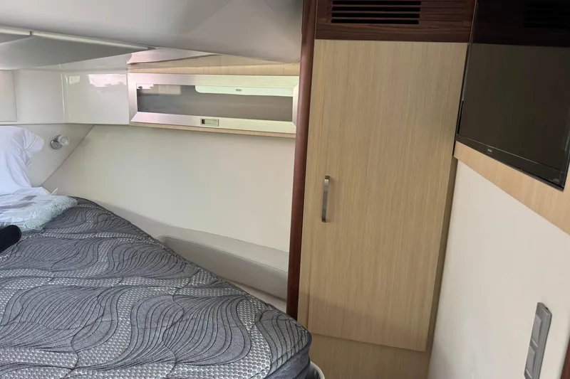 Slide: The Image of 2026 Regal 36 Grande Coupe interior cabin with bed, wardrobe, and TV. - 31