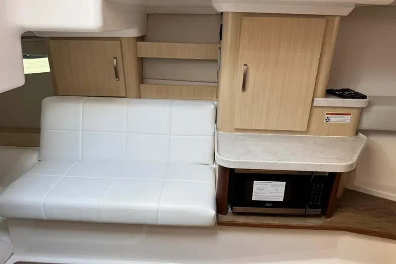 Slide: The Image of Interior of 2026 Regal 36 Grande Coupe with white seating and wooden cabinetry. - 34