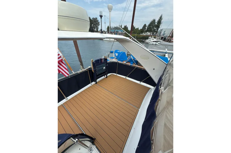 Slide: The Image of 1997 Bayliner 3788 Command Bridge Motoryacht with spacious deck and scenic marina view. - 12