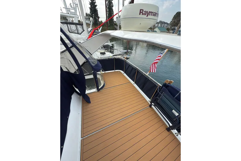 Slide: The Image of 1997 Bayliner 3788 Command Bridge Motoryacht deck with wood finish and American flag. - 13