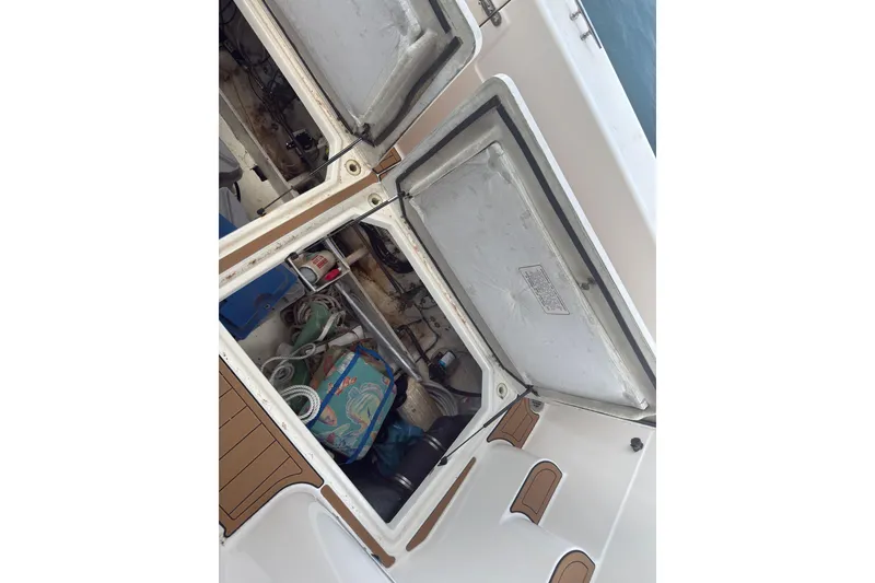 Slide: The Image of Open storage compartment on 1997 Bayliner 3788 Command Bridge Motoryacht, showing various boating supplies. - 15