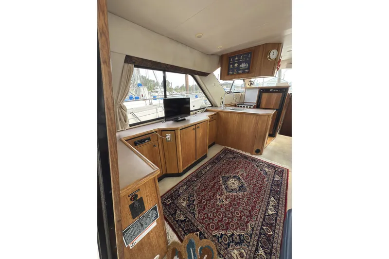 Slide: The Image of Interior of 1997 Bayliner 3788 Command Bridge Motoryacht with wood cabinetry and patterned rug. - 17