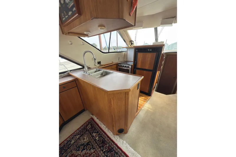 Slide: The Image of Interior of 1997 Bayliner 3788 Command Bridge Motoryacht with kitchen and wooden cabinetry. - 19