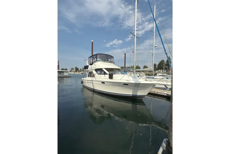 Slide: The Image of 1997 Bayliner 3788 Command Bridge Motoryacht docked in a marina under a clear sky. - 2