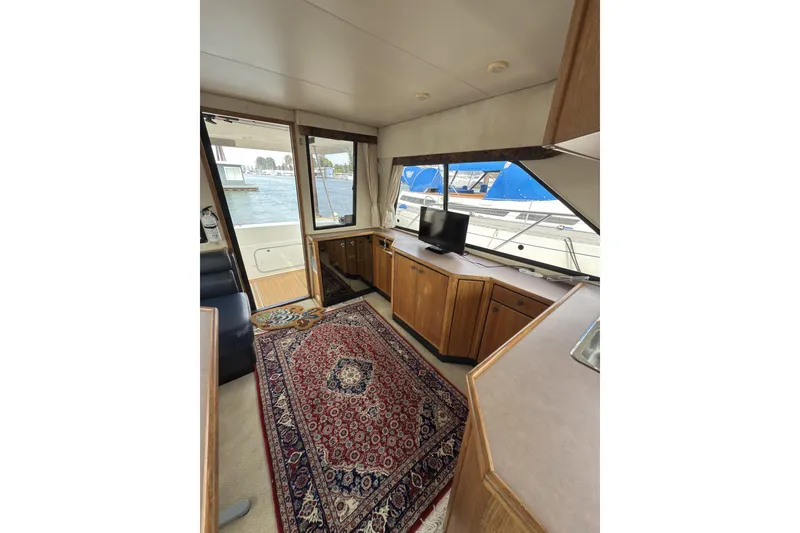Slide: The Image of Interior of 1997 Bayliner 3788 Command Bridge Motoryacht with elegant wood cabinetry and patterned rug. - 20
