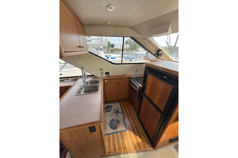 Slide: The Image of 1997 Bayliner 3788 Command Bridge Motoryacht kitchen with wood cabinetry and dual sink. - 21