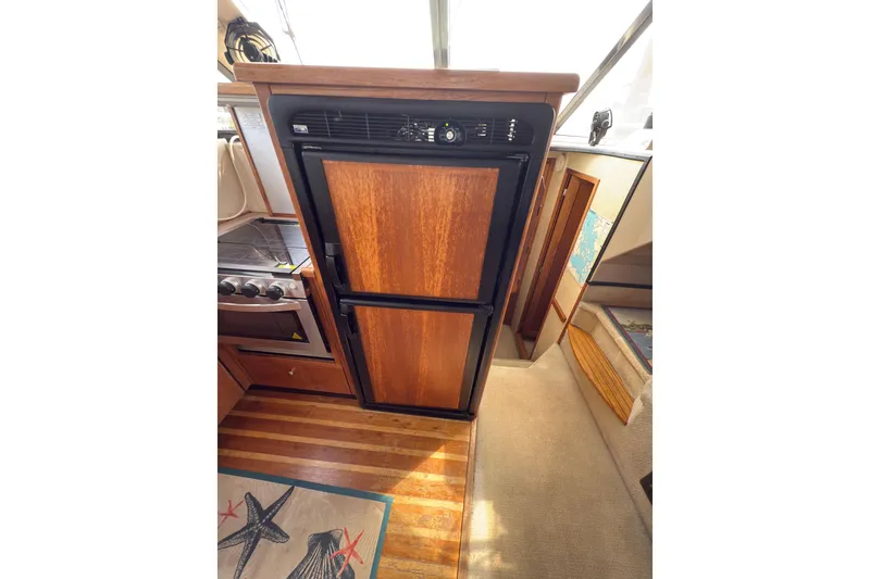 Slide: The Image of 1997 Bayliner 3788 Command Bridge Motoryacht interior with wood-paneled kitchen and appliances. - 22