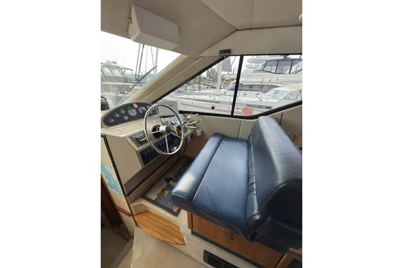 Slide: The Image of Interior of 1997 Bayliner 3788 Command Bridge Motoryacht with steering wheel and blue seating. - 26