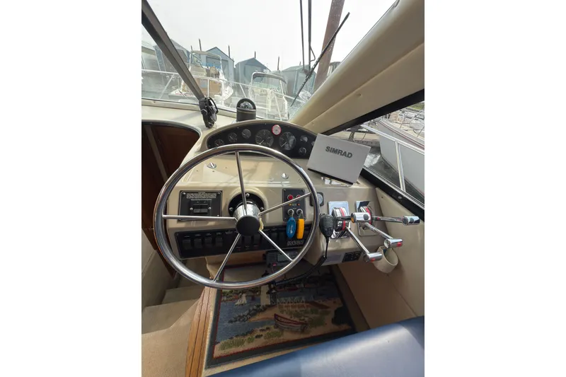 Slide: The Image of 1997 Bayliner 3788 Command Bridge Motoryacht helm with steering wheel and navigation equipment. - 27