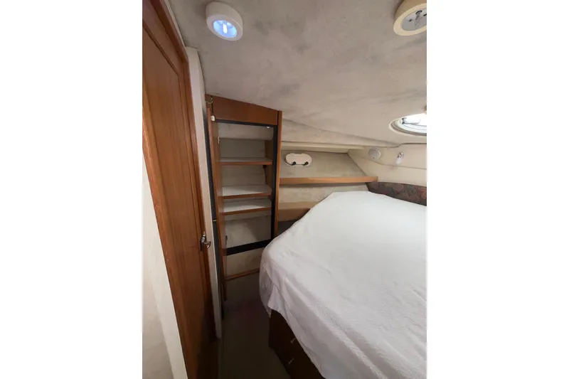 Slide: The Image of 1997 Bayliner 3788 Command Bridge Motoryacht cabin with bed and storage shelves. - 33