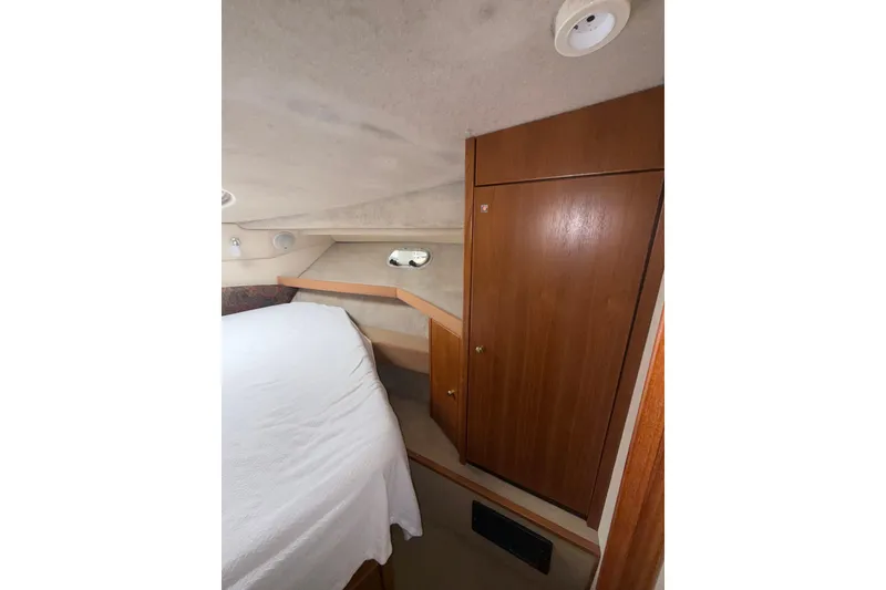 Slide: The Image of 1997 Bayliner 3788 Command Bridge Motoryacht interior cabin with bed and wooden cabinetry. - 34