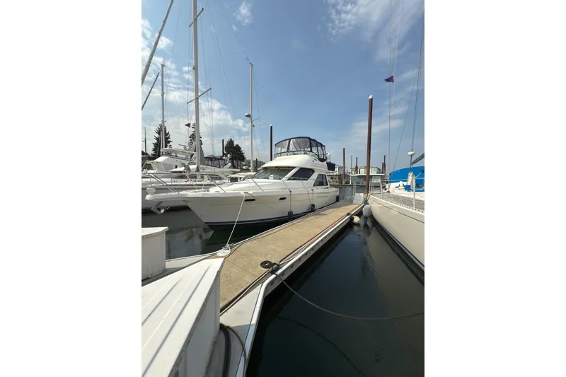 Slide: The Image of 1997 Bayliner 3788 Command Bridge Motoryacht docked at marina under clear sky. - 4