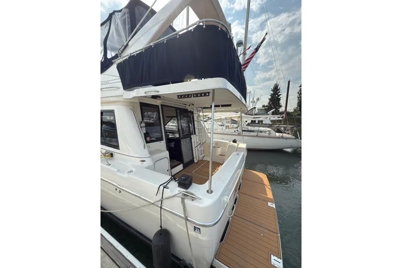 Slide: The Image of 1997 Bayliner 3788 Command Bridge Motoryacht docked, showcasing spacious deck and elegant design. - 7