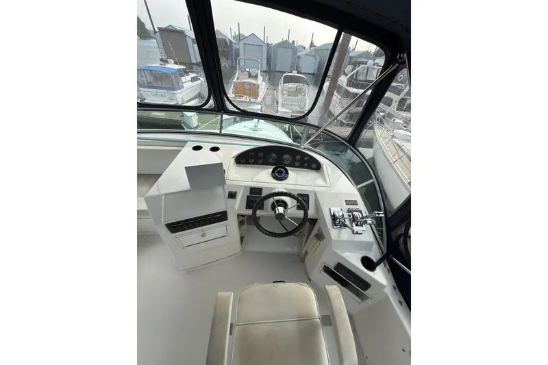 Slide: The Image of 1997 Bayliner 3788 Command Bridge Motoryacht helm with steering wheel and controls. - 9