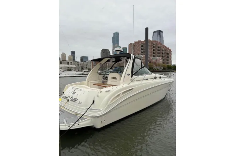 The Image of 2003 Sea Ray 360 Sundancer yacht docked in urban marina with city skyline. - 0