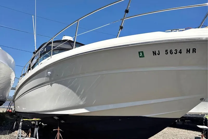 Slide: The Image of 2003 Sea Ray 360 Sundancer boat on stands, clear sky background. - 12