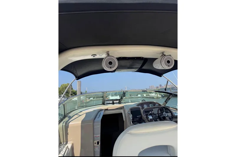 Slide: The Image of 2003 Sea Ray 360 Sundancer cockpit with speakers, steering wheel, and marina view. - 5