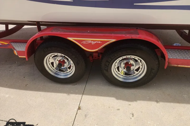 Slide: The Image of Red trailer with Baja branding, dual wheels, and chrome rims for 2005 Baja 242 Islander boat. - 10